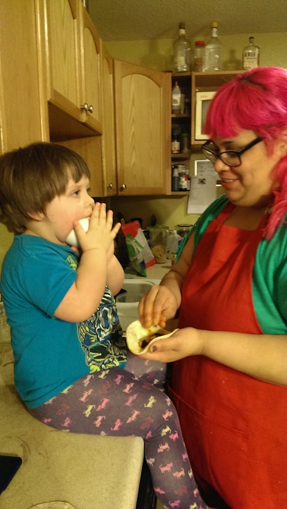 B R Sanders with her son in the kitchen, while he eats 