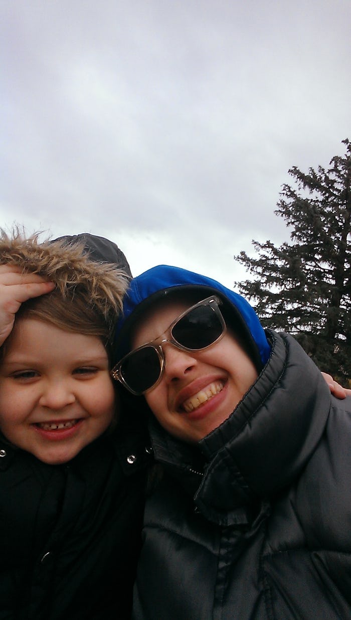 B R Sanders with their child both wearing winter clothing outside and smiling for a selfie