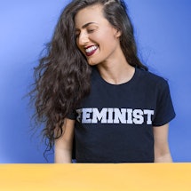 A woman wearing a t-shirt with a "feminist" written over it