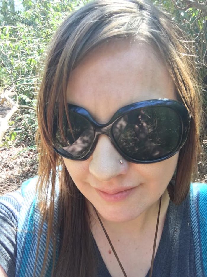 Elizabeth Broadbent wearing black sunglasses and a teal shirt in a selfie