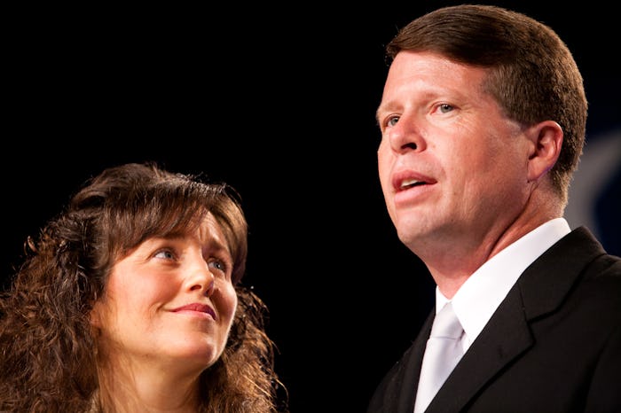 Jim Bob Duggar speaking and Michelle Duggar looking up at him