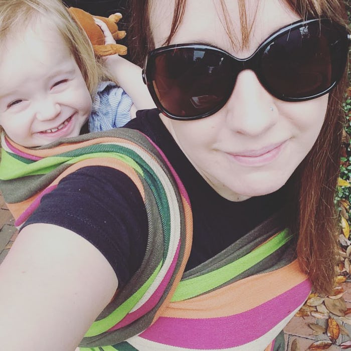 A crunchy mom carrying her baby in a wrap on her back