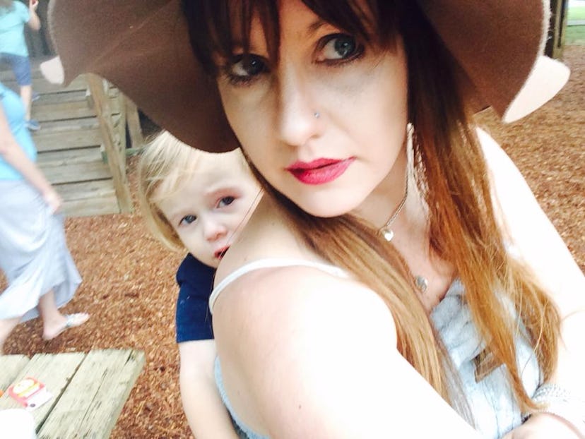 A mother taking a selfie with her kid while wearing a hat