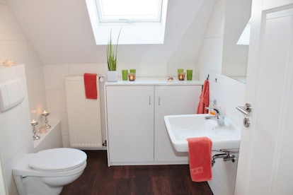 White small modern toilet with a sink, locker, radiator and toilet bowl
