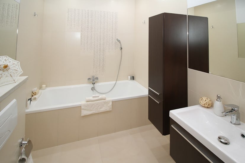 A modern looking toilet with a big white bath tub