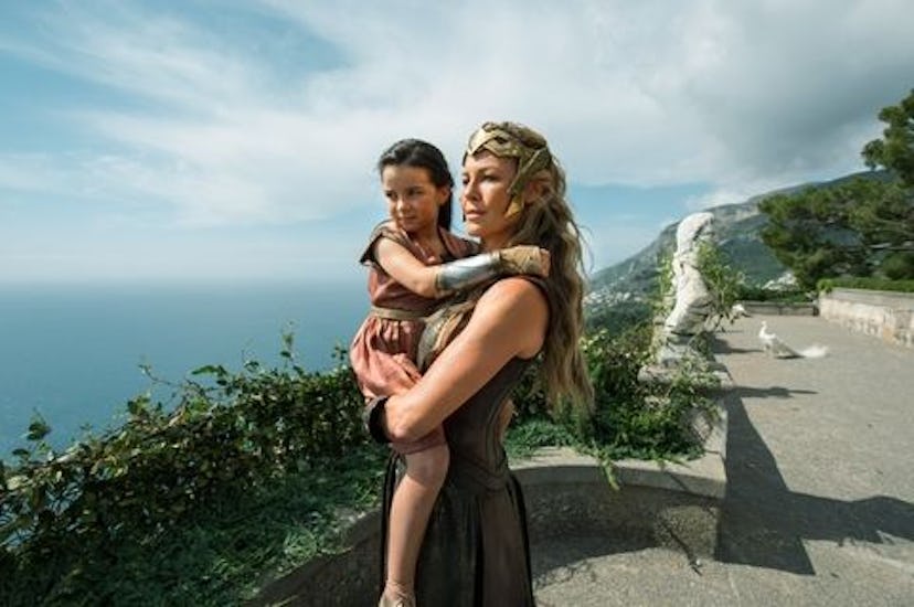 Queen Hippolyta played by Connie Nielsen holds a small girl