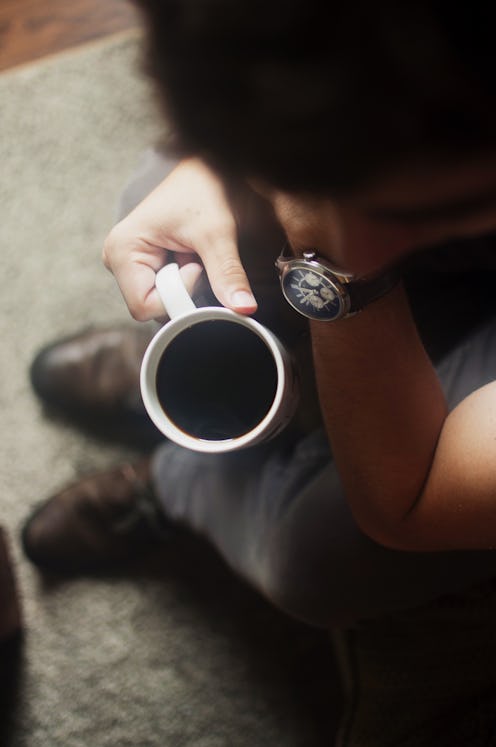 Man holding a cup of black coffee