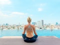 A woman meditating on a dock to reduce holiday stress