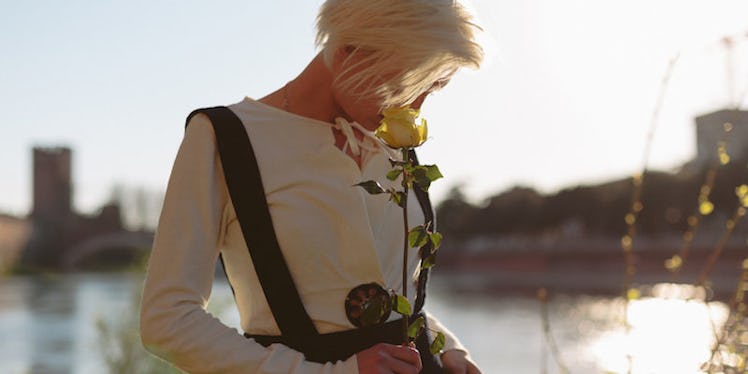 A blonde girl standing in a white shirt