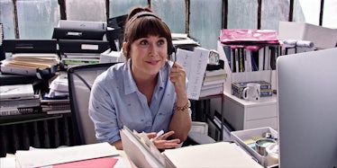 An actress Christina Scherer sitting behind the office desk.