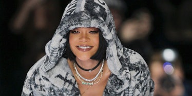 Rihanna with a short black bob, various necklaces and a black and white hoodie