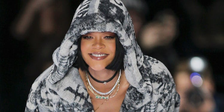 Rihanna with a short black bob, various necklaces and a black and white hoodie
