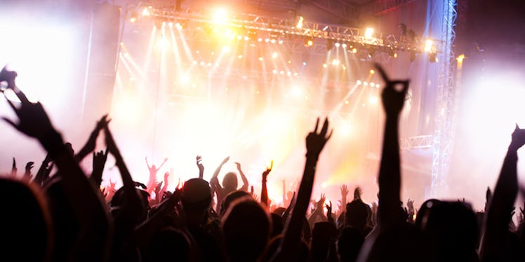 A crowd dancing to a performance at a music festival.