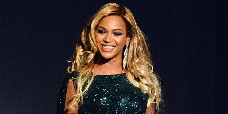 Beyonce in a black sequin top and long earrings, smiling