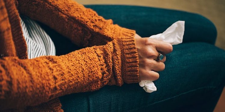 An anxious woman sitting and holding a tissue