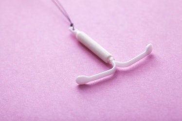 A white IUD on a pink platform