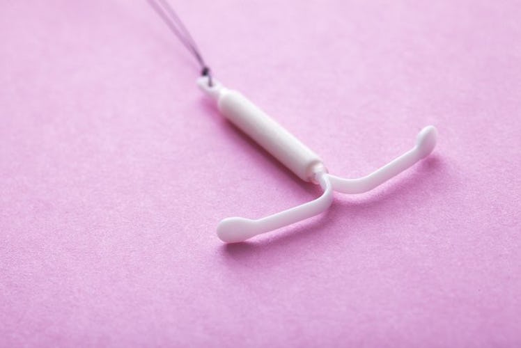 A white IUD on a pink platform