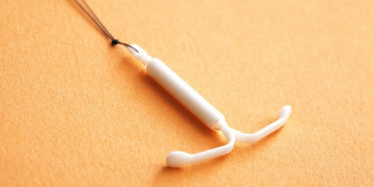 A white IUD on a yellow platform