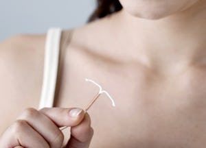 A woman holding an IUD