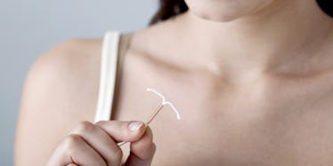 A woman holding an IUD