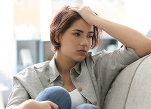 A depressed woman sitting on a couch