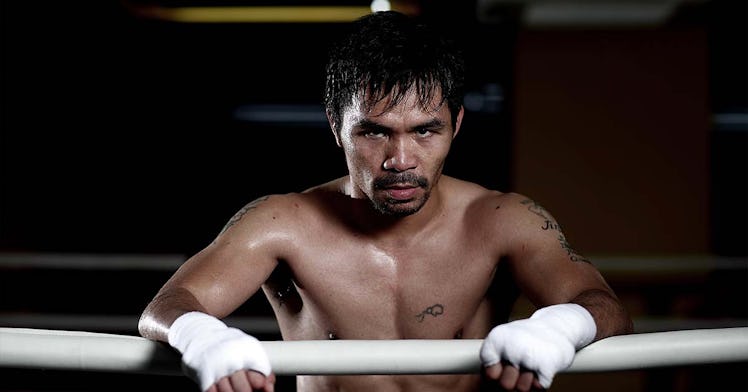 Manny Pacquiao leaning against the fence of a boxing ring