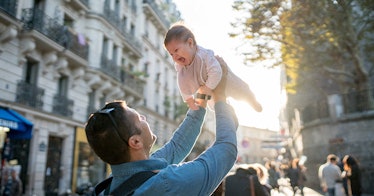 A parent lifting a baby into the air.