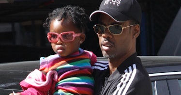 Chris Rock holding his daughter while both are wearing sunglasses