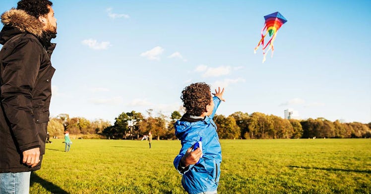 A father teaching his son how to kite