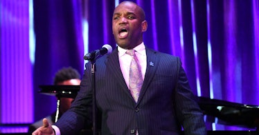 Lawrence Brownlee performing live in a navy suit, white shirt and beige tie
