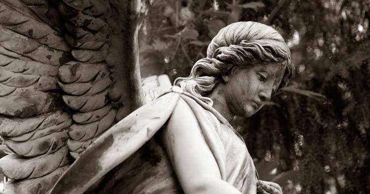 A stone statue of an angel in the park