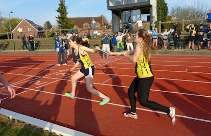 Two girls running a relay race