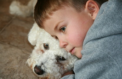 A little boy lying down with his head on his dog
