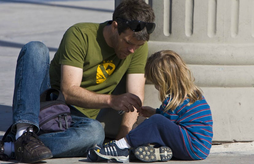 A father sitting outdoors with his son 