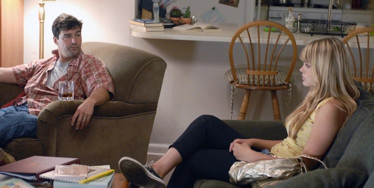 A father sitting in a living room with his teenage daughter