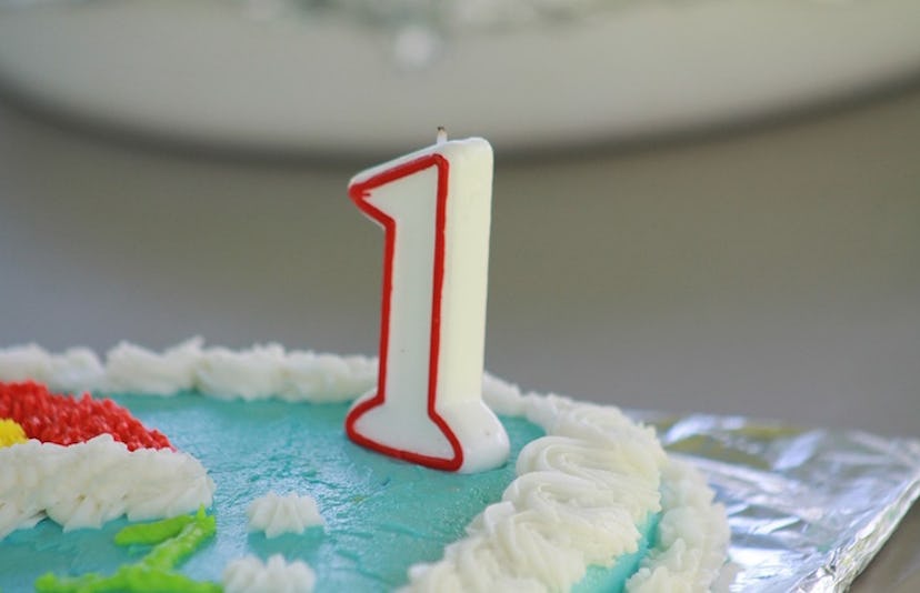 A birthday cake with a number 1 candle on it 