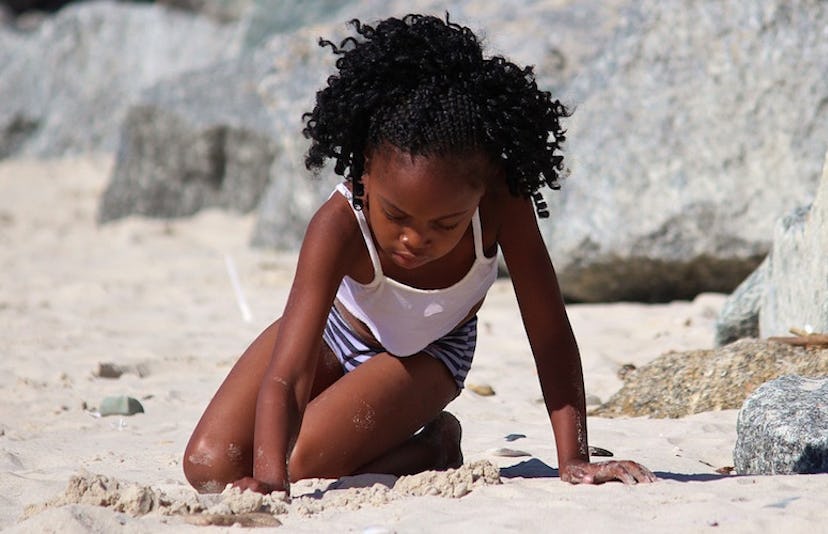 A young girl playing with sand