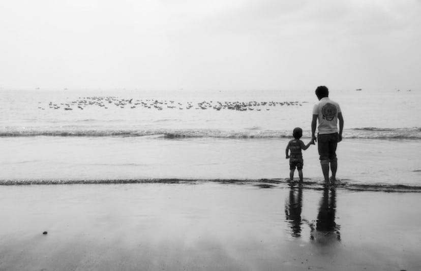 Father and son standing together in the sea