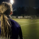 Girl on soccer field at night.