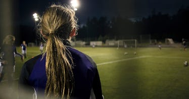 Girl on soccer field at night.