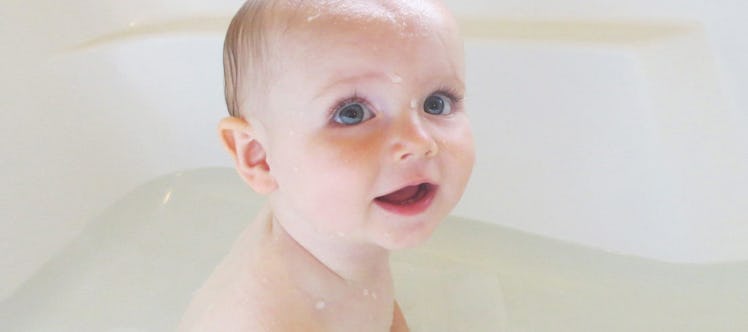 A naked baby in the bath tub.