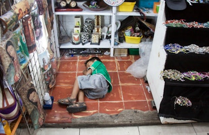 Kid Sleeping On A Shop Floor In Mexico