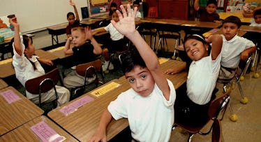 Kids in a classroom in uniform.