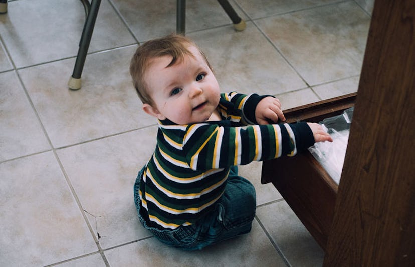 baby reaching into drawer