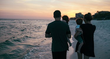 family walking on the beach at sunset