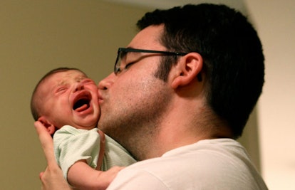 father kissing crying baby
