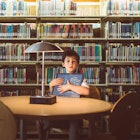 boy holding book in library
