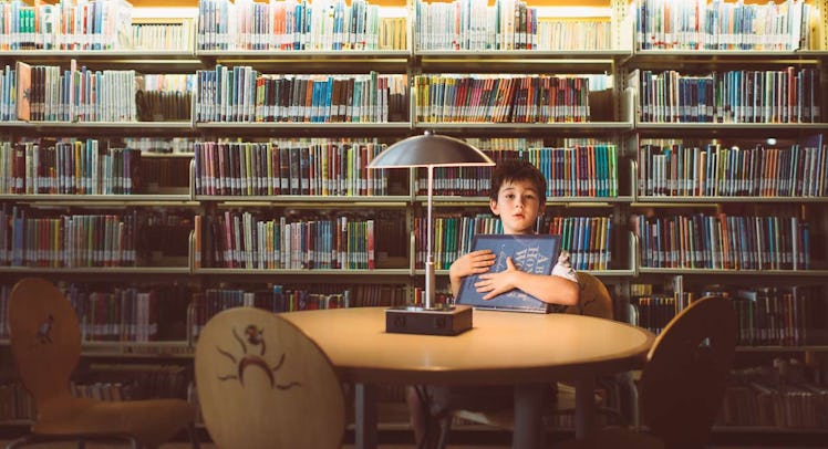 boy holding book in library