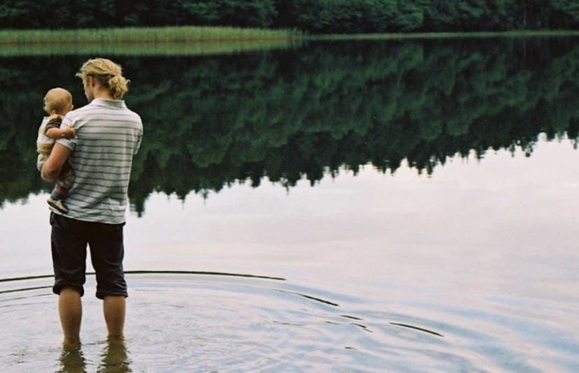 father and baby by a lake