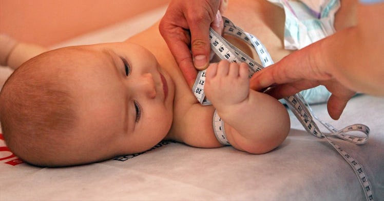 An infant gets measured as part of health check
